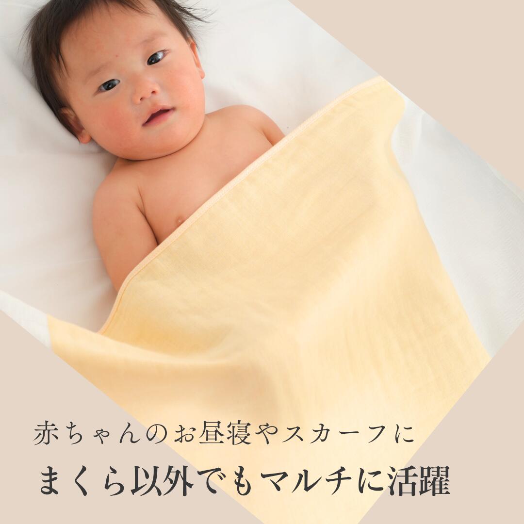 黄色いまくらカバーにくるまれた赤ちゃん。「赤ちゃんのお昼寝やスカーフに」「まくら以外でもマルチに活躍」の文字が入っている