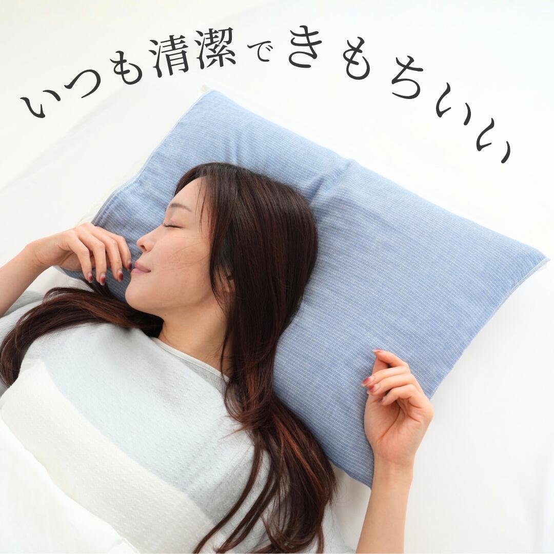 アッシュブルーのまくらカバーを掛けた枕で眠る女性。「いつも清潔できもちいい」の文字が入っている