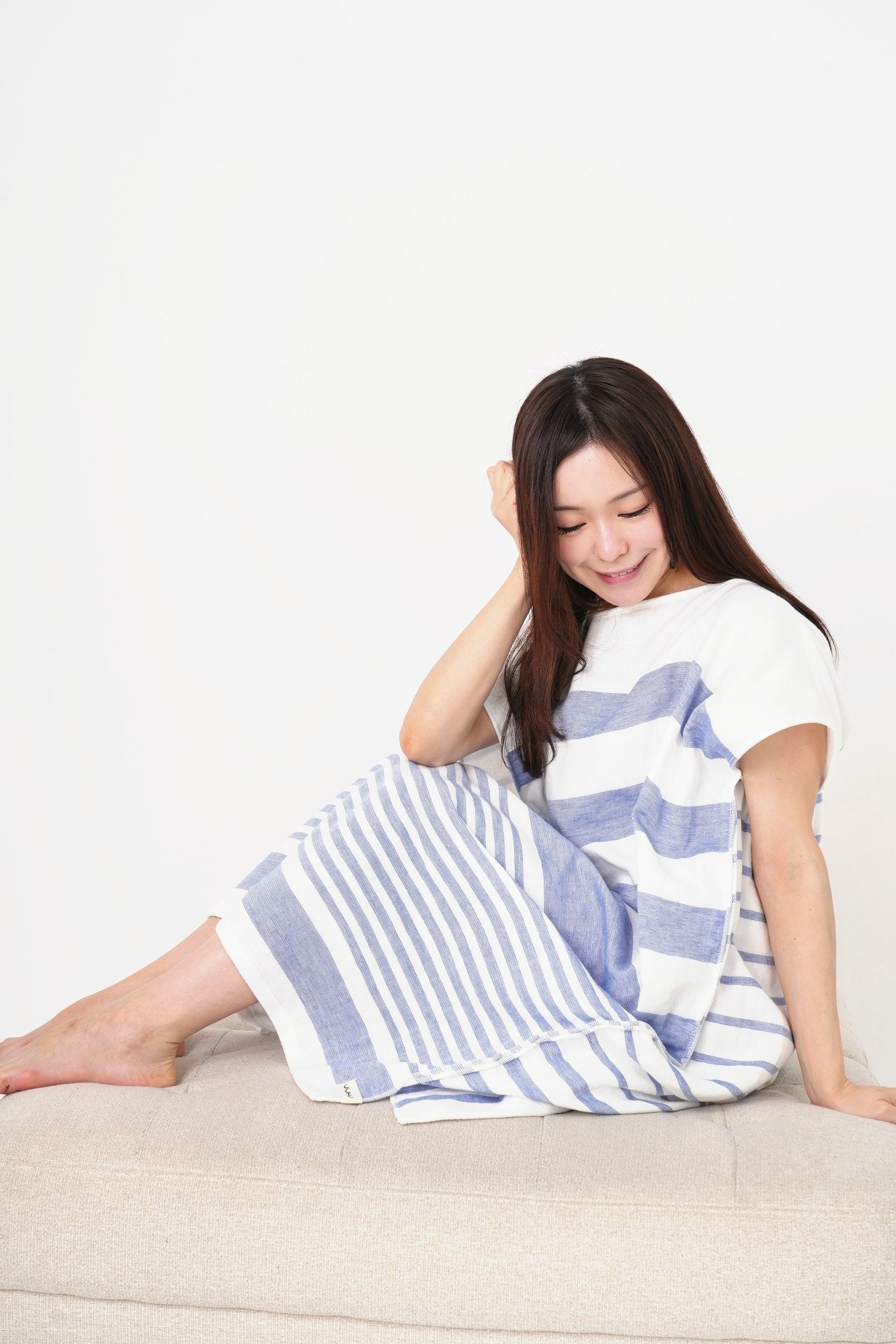 ソファに座り、着るタオル パイル&ガーゼ（Marine）を着た女性